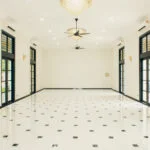 Spacious and elegant Grand Hall at The Agam, featuring chandeliers, large windows, and modern lighting for weddings and events.