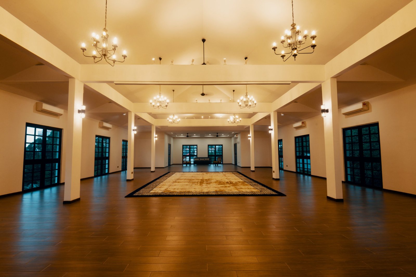 Spacious Upper Hall at The Agam, featuring chandeliers, high ceilings, and elegant flooring, perfect for weddings and large events.