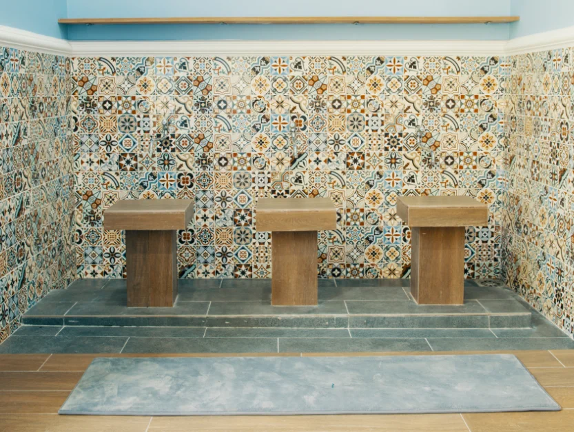Prayer room at The Agam, featuring traditional decorative tiles and modern ablution stations.