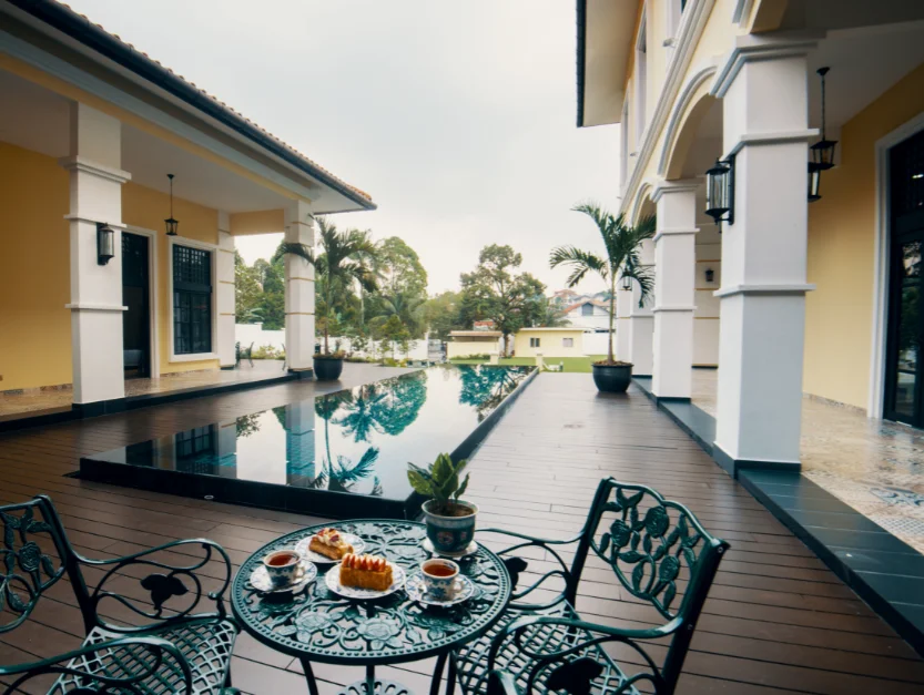 Relaxing poolside area at The Agam with seating, surrounded by elegant architecture and garden views, perfect for events or leisure.