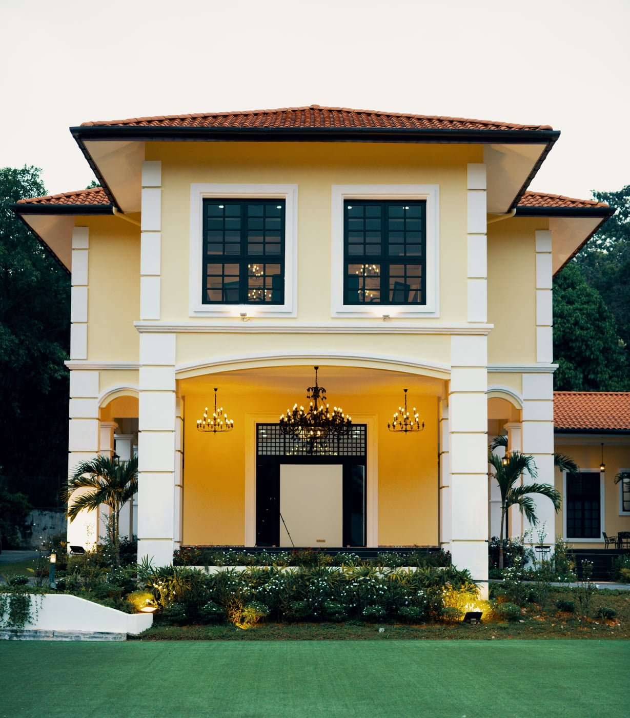 The Agam grand entrance with a manicured lawn, showcasing its colonial-inspired architecture and elegant chandeliers, located in Kuala Lumpur.